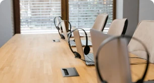 Estação de trabalho com laptops e headsets, pronta para atendimento ao cliente