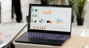 Laptop exibindo gráficos e análises de dados em uma tela representando relatórios de desempenho