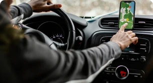 Motorista ajustando o GPS no painel do carro durante a navegação.